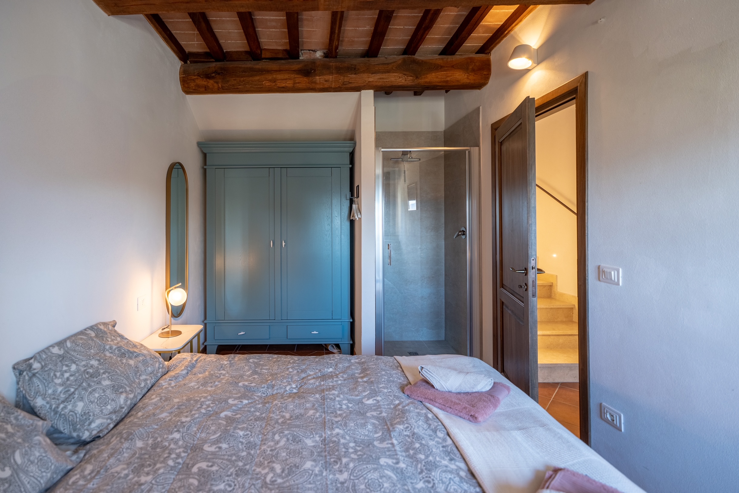 Ground floor queen bedroom with blue armoire and in-room shower