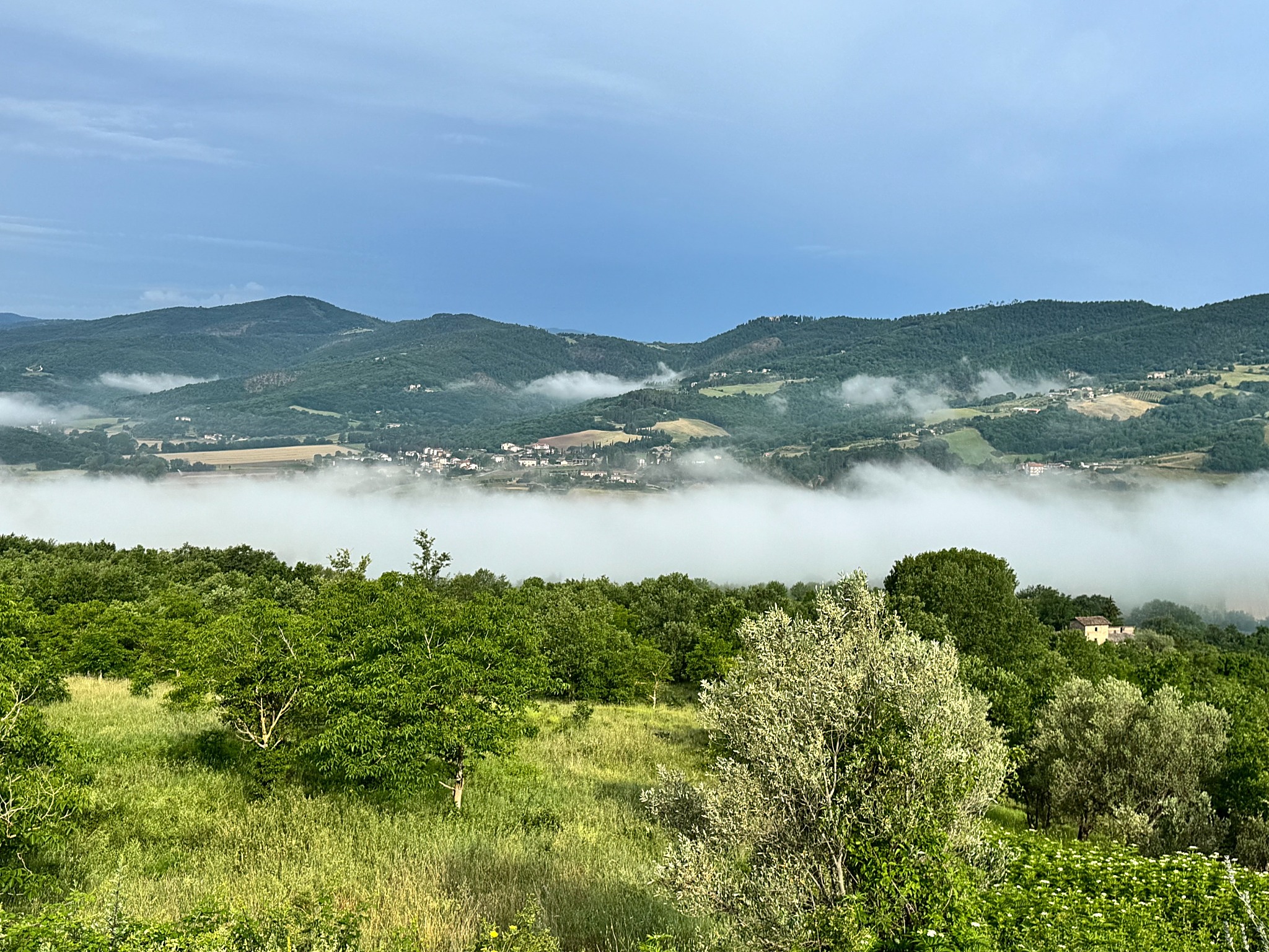 The green Niccone Valley beneath drifting clouds