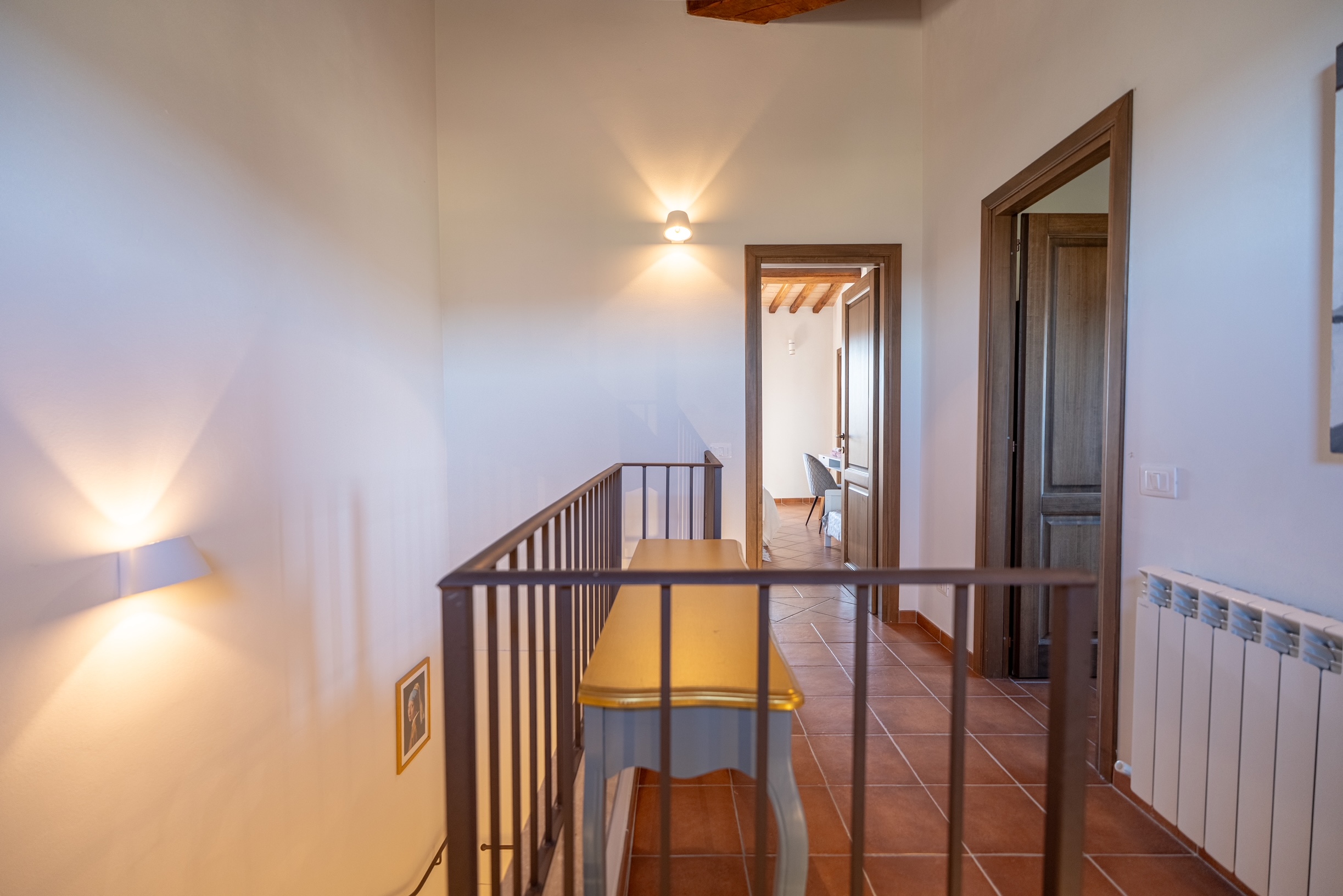 First floor landing with iron railing and bedroom doors