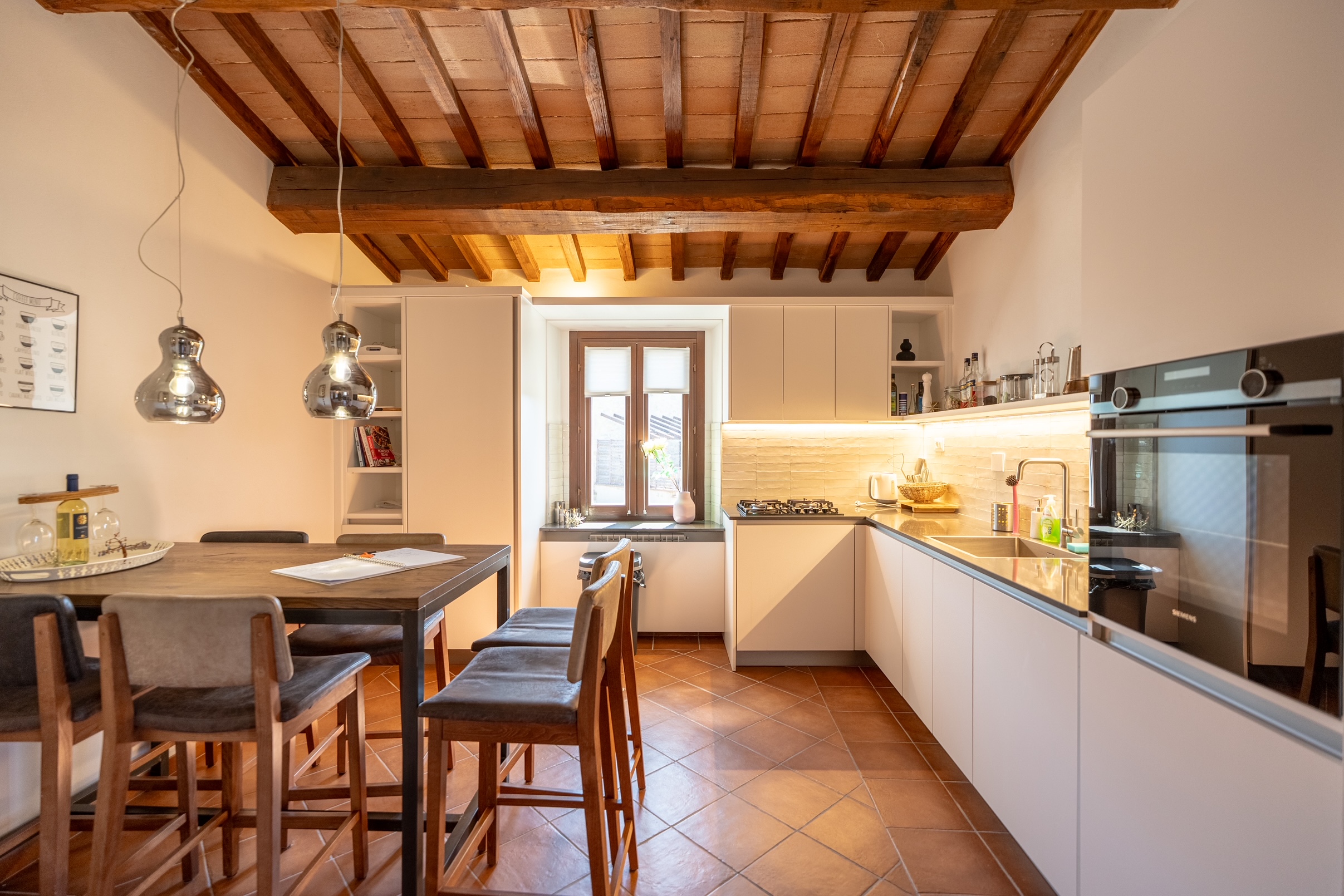 Chef's kitchen with timber beams, pendant lighting and dining for 6